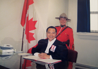 Professor Lai was appointed a Presiding Officer of the Citizenship Ceremony from 1996 to 2003. Here he poses with an R.C.M.P. officer. (Photo courtesy of David Chuenyan Lai).